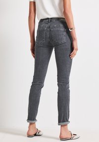 Jean gris ajusté avec taille mi-haute, ourlets retroussés et deux poches arrière, fabriqué en denim à la texture lisse.
