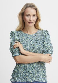 Bluse mit floralem Muster, kurzen Puffärmeln, gerafftem Material und rundem Ausschnitt in Blau-, Grün- und Gelbtönen.