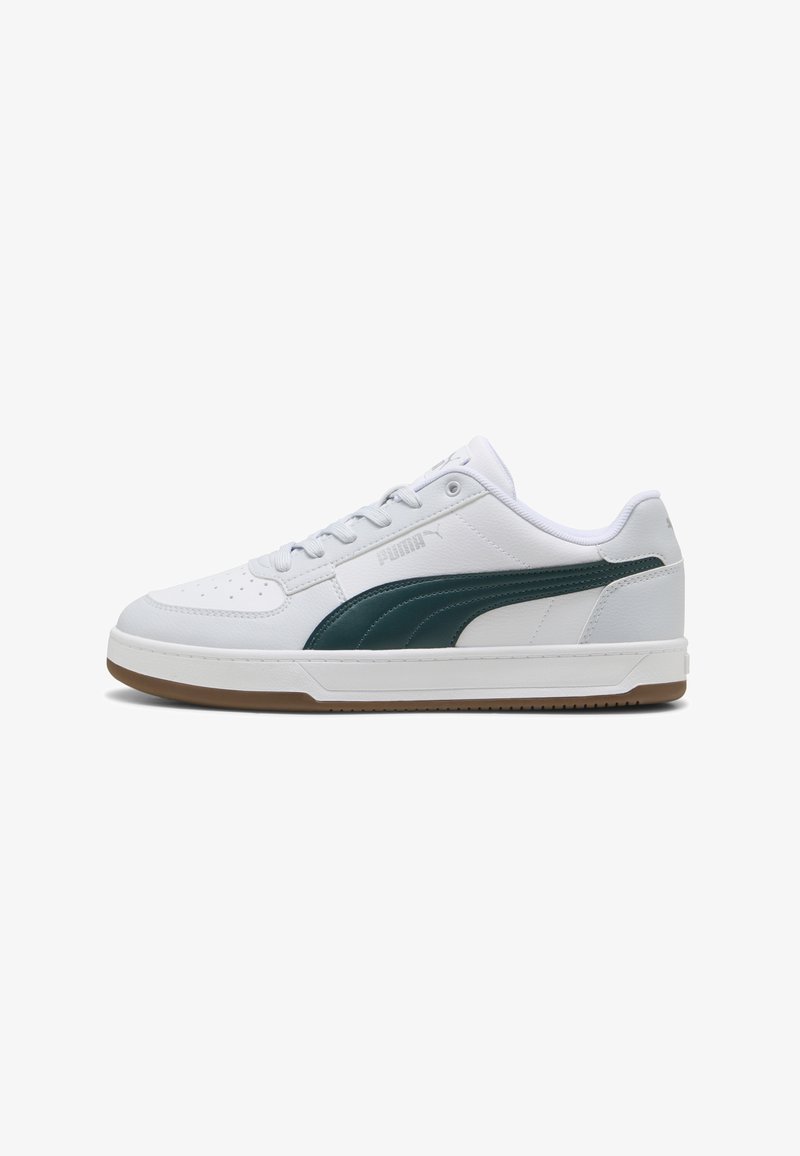 Sneaker atletico bianco con dettagli in pelle verde, tomaia texturizzata, punta perforata, lacci bianchi piatti e suola in gomma naturale.