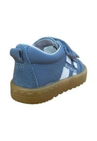 Zapato para niño pequeño de cuero y ante azul con correa de Velcro, acentos blancos, punta redondeada, parte trasera texturizada y suela de goma flexible.