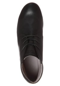 Zapato de cuero negro con punta redondeada, diseño de cordones, textura suave, minimalismo en la marca y un interior acolchado. La suela es ligeramente curva.
