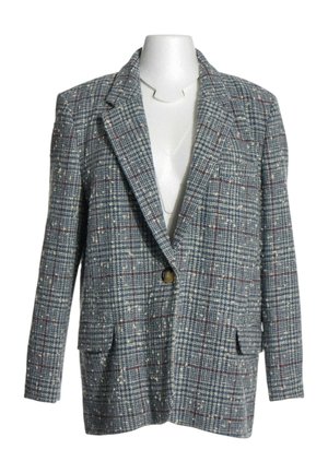 Blazer de cuadros gris de un solo botón con patrón de cuadros azul y rojo, solapas anchas y bolsillos delanteros con solapa en un torso de maniquí blanco.