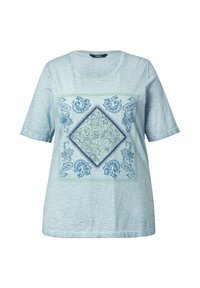 Camiseta de algodón azul claro con mangas cortas y escote redondo. Presenta un estampado floral en forma de diamante en azul y verde en la parte frontal.
