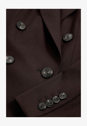 Dobbeltbrystet brun blazer med en glat stofstruktur, der har seks sorte knapper med indgraveret brandnavn og skræddersyede klapper.