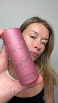 NABLA Lip Candy Oil i en cylindrisk, blushrosa behållare med matt yta. Texten på framsidan inkluderar produktnamn och volyminformation.