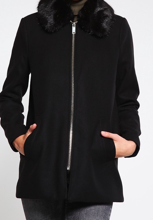 Abrigo negro con cuello de piel sintética, con cremallera frontal, bolsillos laterales y un corte entallado. Tela suave con una textura agradable.