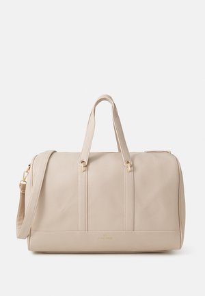 Beige leather duffel bag with a textured surface, two top handles, a detachable shoulder strap, and gold-tone hardware accents.