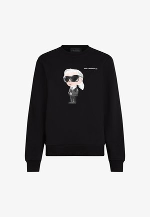 Čierna mikina s kapucňou s karikatúrnym obrázkom postavy v slnečných okuliaroch a obleku, s nápisom "KARL LAGERFELD" nad obrázkom.