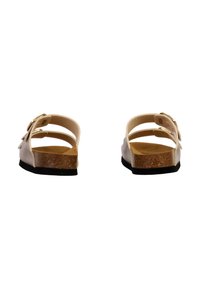 Sandales slip-on beige clair avec semelle intermédiaire en liège, semelle extérieure en caoutchouc noir et doubles sangles réglables. Texture lisse et design ouvert.