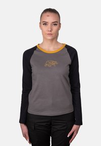 Graues Langarmshirt mit schwarzen Ärmeln, ausgestattet mit einem gelben Kragen und einem geometrischen Bärenmotiv in der Mitte. Weicher Stoff, lässige Passform.