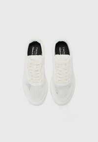 Hvite mesh sneakers har et pustende overtrekk med en strukturert design, flate lisser og en polstret såle for komfort og støtte.