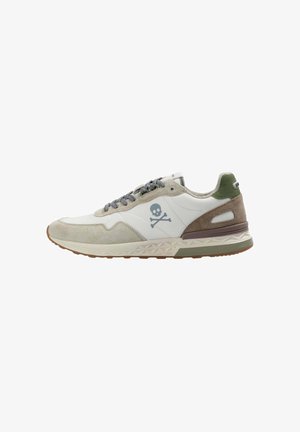Zapatillas de hombre que combinan materiales de ante y cuero, predominantemente blancas con acentos en gris claro y verde, y un logo de calavera en el lateral.
