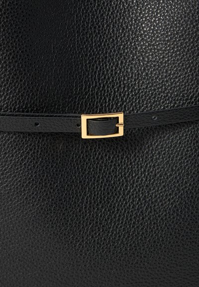 Bolso de cuero negro con un acabado texturizado. Presenta una delgada correa negra y una hebilla rectangular dorada como detalle de acento.