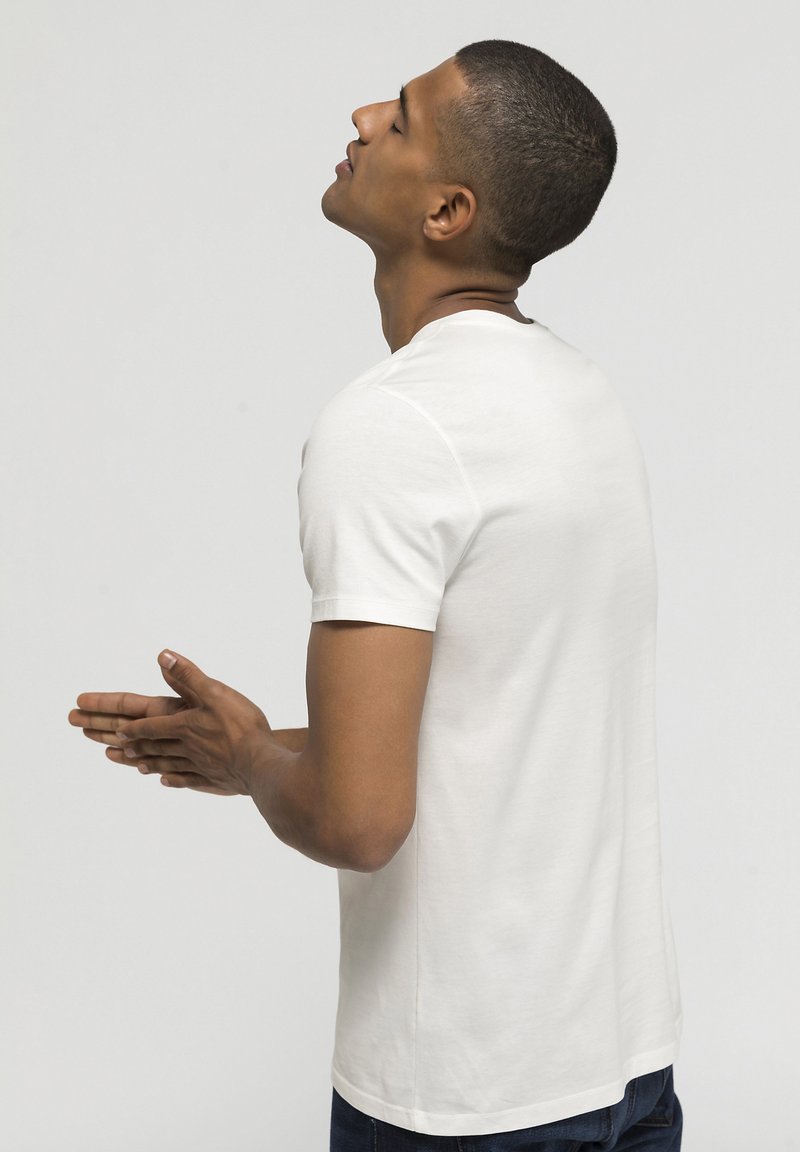 White short-sleeve t-shirt made from a smooth cotton blend, featuring a crew neck and relaxed fit, with minimal stitching details on the back.