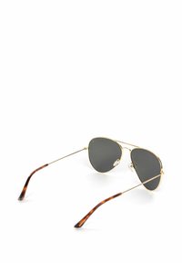 Pilotní sluneční brýle se zlatými kovovými rámy, šedě tónovanými skly a zavoskovanými konci stran. Mají nastavitelné nosní polštářky.