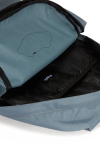 Harmaa ja musta reppu, jossa on teksturoitu pinta, vetoketjulla avautuva suuaukko ja sisätasku, jossa on logotagi ja hillitty auton ääriviivamuotoilu.