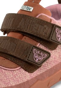Scarpe con cinturino in tessuto marrone e rosa, con chiusura a doppio velcro, caratterizzate da un logo a forma di faccia di animale rosa e superiore testurizzato, suola in gomma resistente.