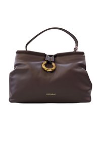 Sac à main en cuir marron de forme arrondie. Présente un accent en matériel circulaire doré et une anse supérieure. Logo en doré à la base.