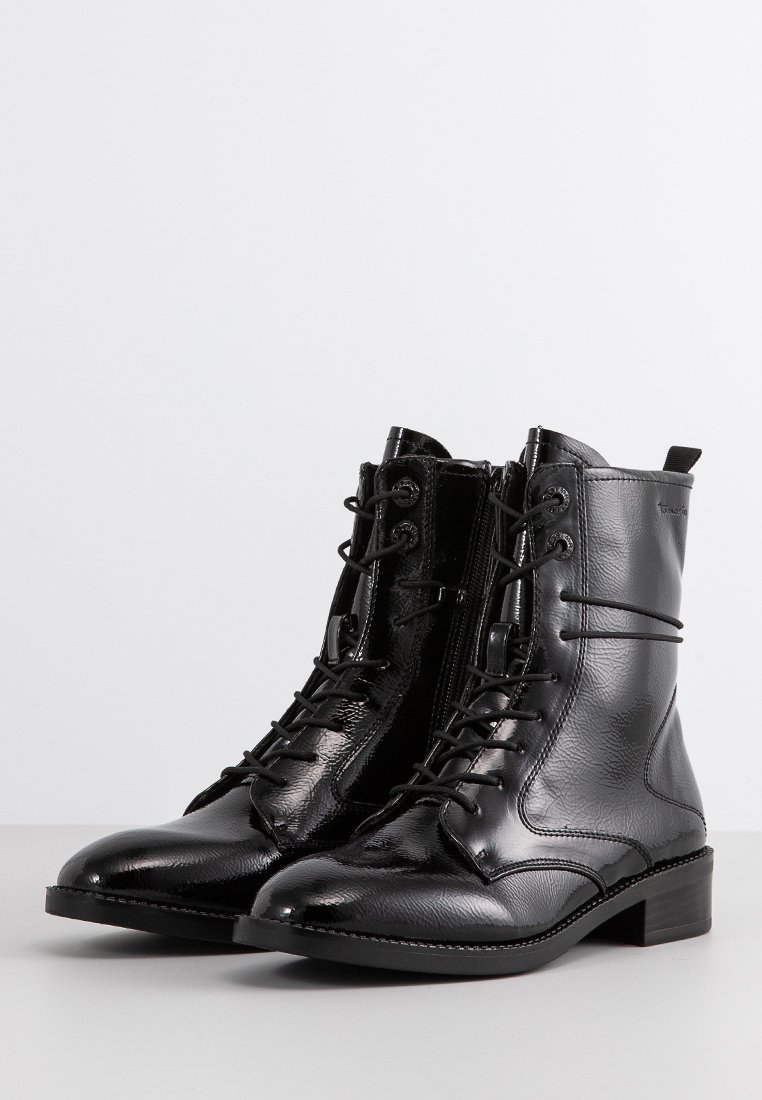 Glanzende zwarte veterschoenen tot de enkels met zijritsen en trekhulptabs, met lage hakken en een textuurleerafwerking.