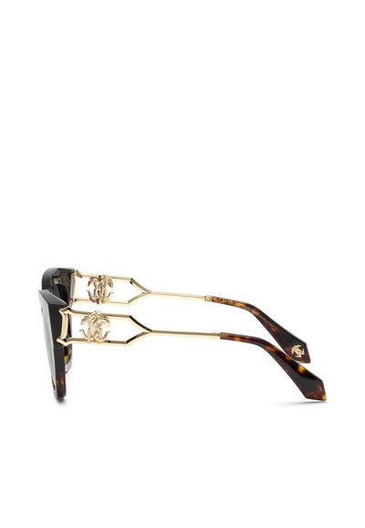 Lunettes de soleil noires et écaille avec des branches en métal doré présentant des détails de logo décoratifs entrelacés.
