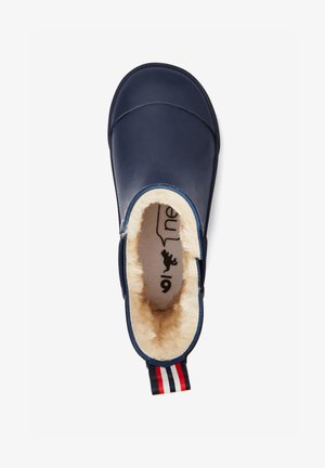 Chausson bleu marine à enfiler avec doublure en fourrure crème et languette de talon rayée rouge, blanche et bleue, vu de dessus.