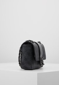 Lille sort håndtaske med en tekstureret finish, der har en klaplukning, kædetrækk og et subtilt logo-mønster over det hele.