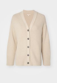 Beige svetr vyrobený z měkkého pleteného materiálu. Má výstřih do V, šest předních knoflíků a žebrované manžety s volným střihem.