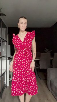 Red floral wrap dress with ruffled sleeves, tied at the waist, featuring a flowing tiered skirt and small white flower patterns.