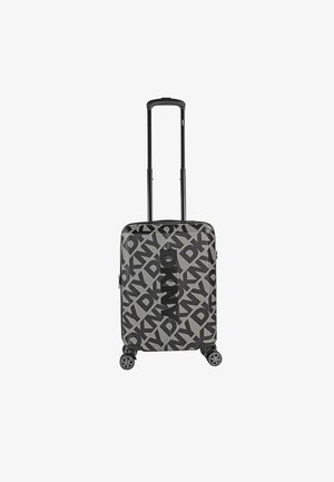 Maleta rígida en gris con un patrón geométrico negro, equipada con un asa retráctil y cuatro ruedas multidireccionales.
