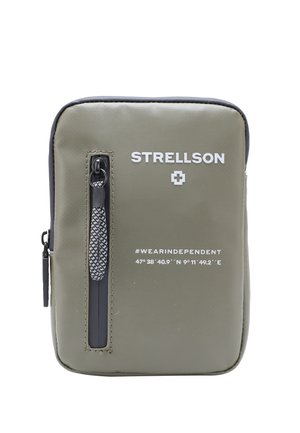 Grüne Polyester-Tasche mit strukturierter Oberfläche, schwarzem Reißverschluss, weißem Logo und Text sowie einem dekorativen Reißverschlussanhänger. Kompakte rechteckige Form.