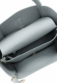 Grijze leren handtas interieur met een gestructureerde afwerking, met een groot, plat vak en een kleiner geaccentueerd compartiment met rits. Gouden hardware accenten.