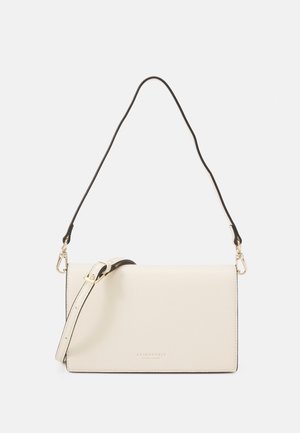 Sac rectangulaire en cuir crème avec une bandoulière noire. Présente des accessoires dorés et un logo embossé à l'avant. Texture lisse et design minimaliste.