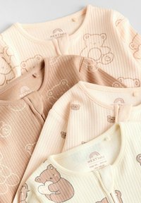 Four baby bodysuits in ribbed fabric: beige and light brown, featuring bear patterns. Center buttons and soft, textured cotton material.