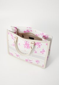 Grande borsa a spalla in materiale bianco con motivo floreale rosa, accenti beige, due manici e una tasca interna con cerniera.