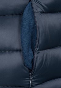 Doudoune bleu foncé avec une poche zippée, dotée d'une doublure en polaire douce. L'extérieur présente une texture lisse et matelassée.