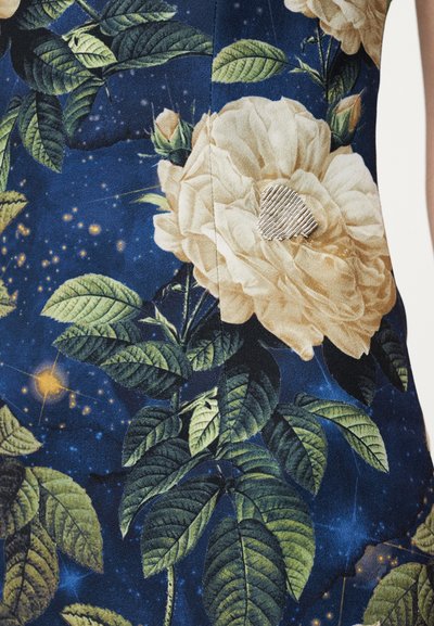 Bloemenstof met grote beige rozen en groene bladeren op een donkerblauwe achtergrond met sterachtige accenten; bevat een zilveren hartvormig detail.