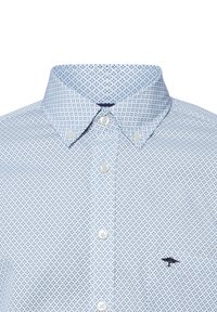 Camicia azzurro chiaro con un motivo geometrico blu scuro. Presenta un colletto e un piccolo logo ricamato sul petto.
