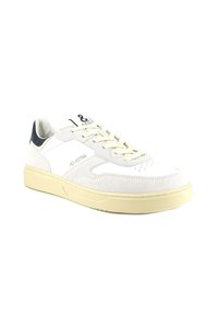 Sneaker bianca con materiali in suede e pelle, dotata di suola in gomma crema, lacci beige chiaro e un accento sul tallone blu scuro.