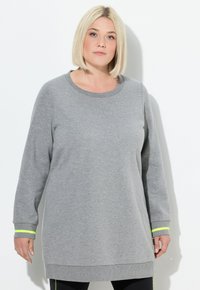 Sudadera gris de manga larga con cuello redondo y rayas de acento en verde neón en los puños. Tejido suave y diseño de corte relajado.