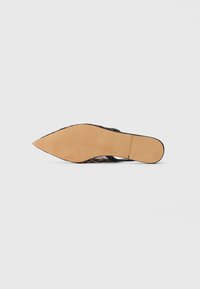 Pointed-toe shoe with a leopard print pattern on the upper, black straps, and a smooth tan sole with textured detailing.