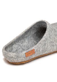 Szare filcowe kapcie o miękkiej fakturze, otwartym designie oraz brązowej skórzanej metce z napisem "magicfelt". Brązowa podeszwa z minimalnym bieżnikiem.