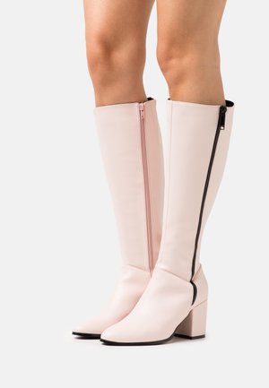 Knee-high, bladoróżowe buty wykonane z gładkiej sztucznej skóry, z bocznym zamkiem błyskawicznym i blokowym obcasem, z akcentem czarnego zamka.