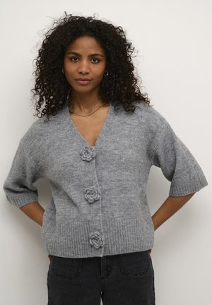 Hellgrau gestrickte Strickjacke mit V-Ausschnitt, drei blumigen Knopfakzenten, kurzen Ärmeln und geripptem Saum. Strukturiertes Wollmaterial.