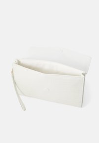 Bolso de mano blanco con un patrón texturizado de cocodrilo, que cuenta con un cierre de solapa superior, una correa para la muñeca y un forro interior liso.