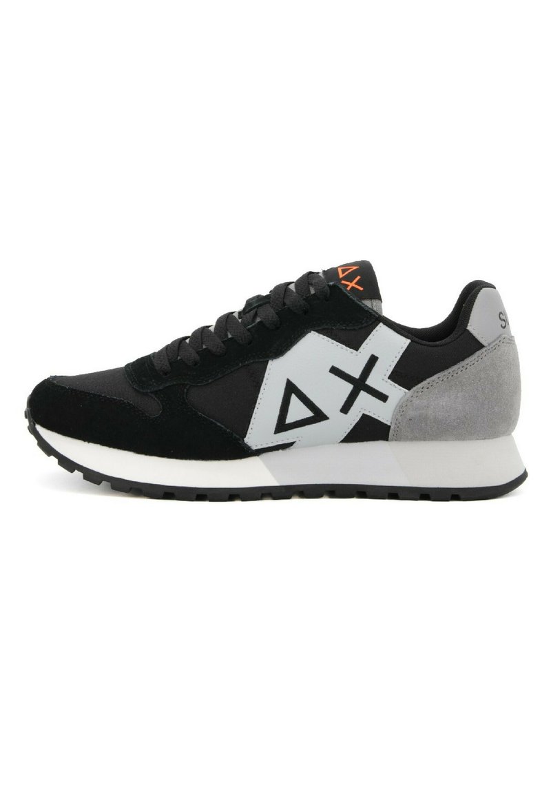 Zapatilla en negro y gris con materiales de ante y malla, que cuenta con una entresuela blanca, suela de goma y diseños de logotipos geométricos.