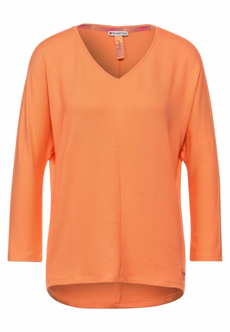 Sweater orange à col en V avec des manches trois-quarts, texture côtelée et un ourlet arrière plus long. L'étiquette indique "Street One."