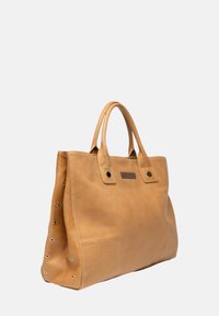 Sac fourre-tout en cuir tan avec deux poignées supérieures, présentant une silhouette rectangulaire, des accents en clous en métal d'un côté et une poche sur le devant.