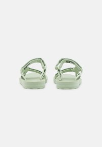 Sandalias verdes con plantilla texturizada y diseño de tira trenzada. Material flexible y correas traseras ajustables para un ajuste seguro.