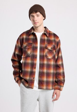 Geruite shirt in oranje, bruin en crème tinten, met twee borstzakken, een knoopsluiting en een ontspannen pasvorm. Zacht, textuurstof.