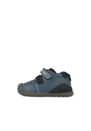 Zapato infantil azul con suela de goma, que cuenta con dos correas de velcro ajustables y un material superior suave, punta redondeada y detalles en las costuras.